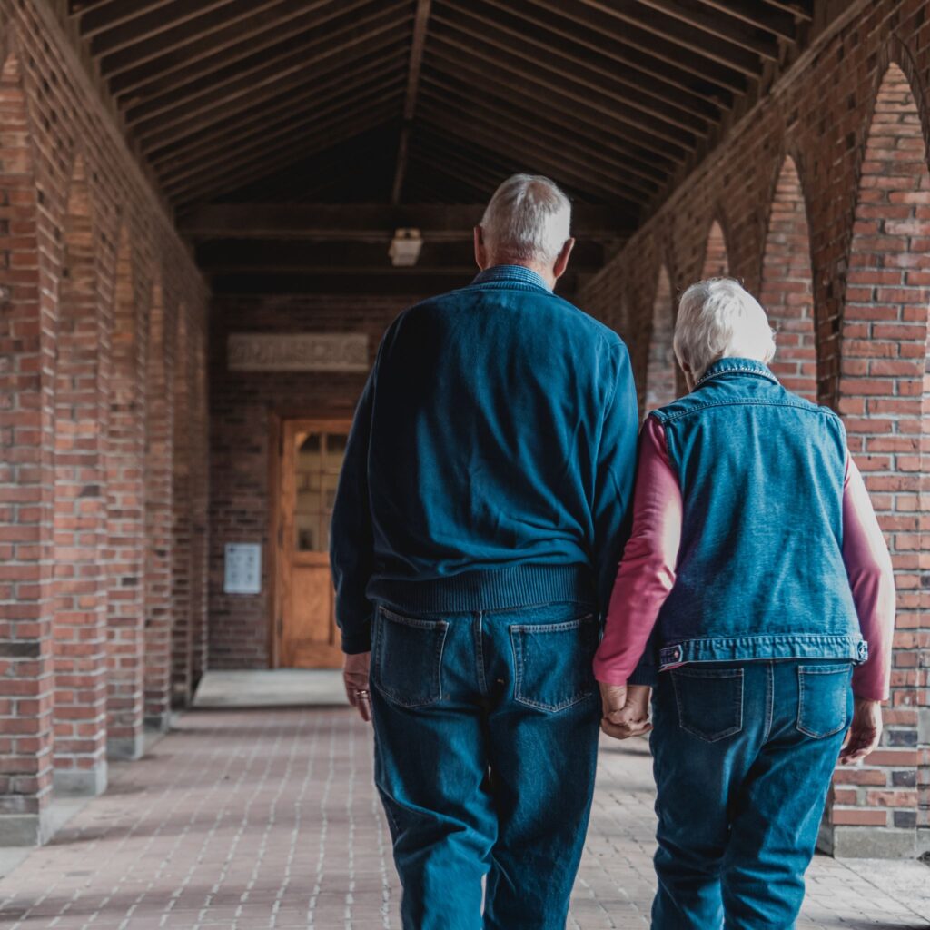 dos ancianos caminando de la mano bajo techo casa hogar la familia